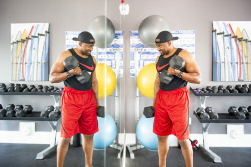 guy using dumbbells in evolve fitness center new workout