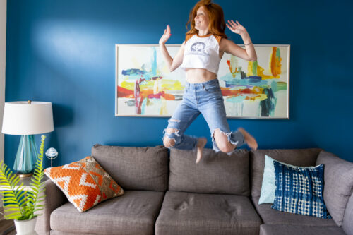 valentine's day gift ideas girl jumping on couch with throw pillows evolve companies