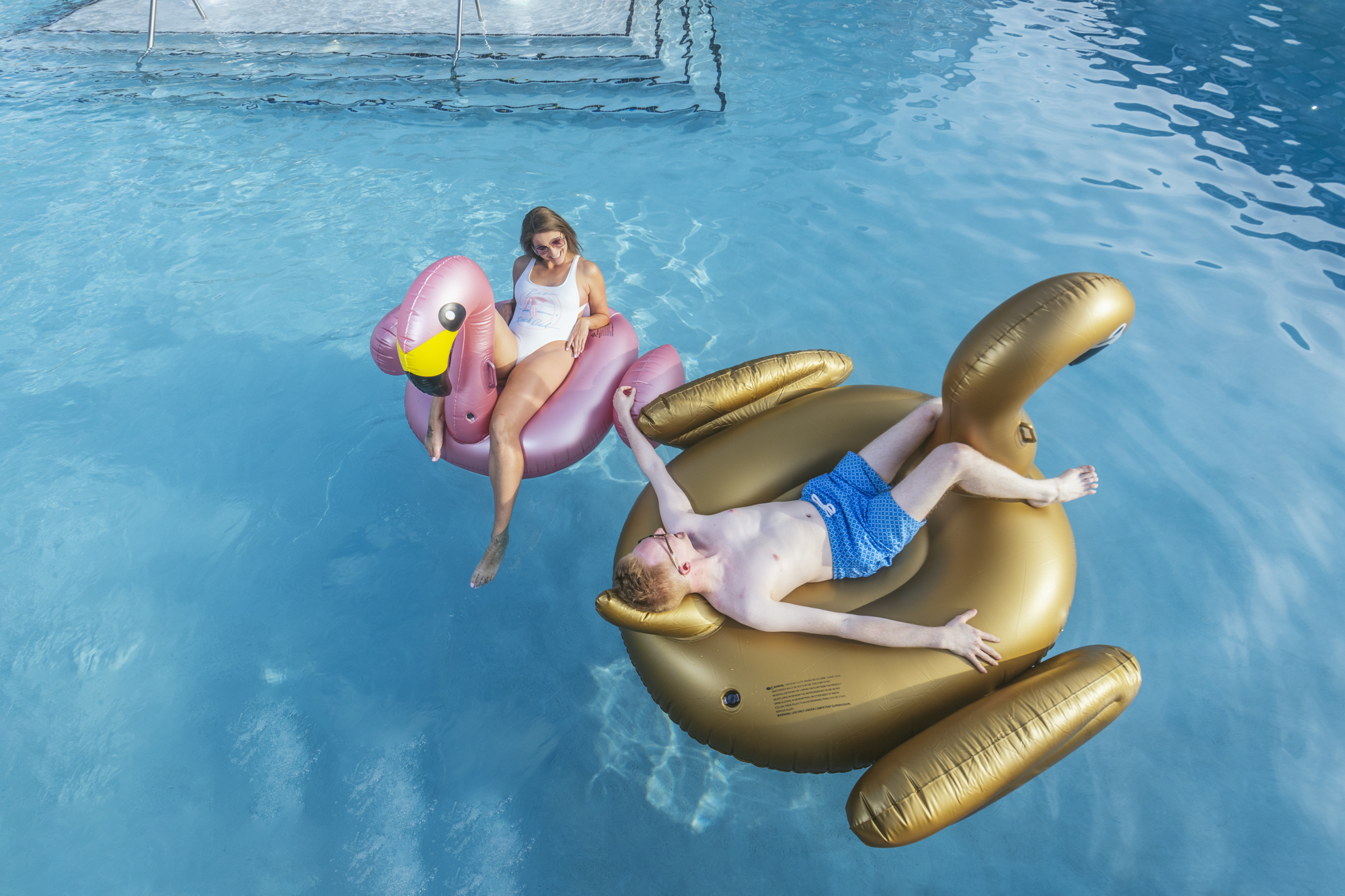 people on giant floaties in pool at evolve community