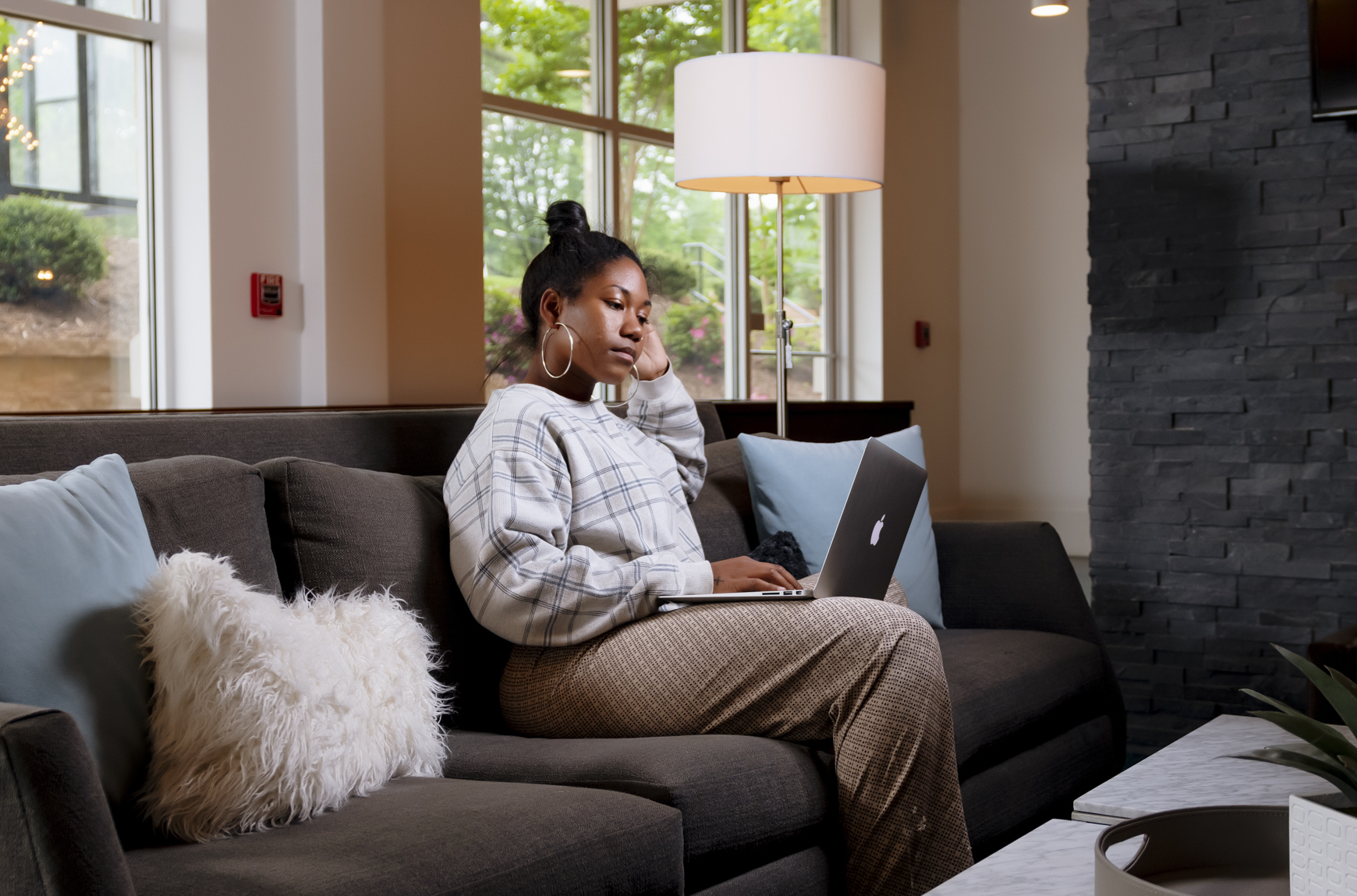 evolve-blog-refresh-your-space-home-office-fall-cleaning girl working from laptop on couch evolve blog