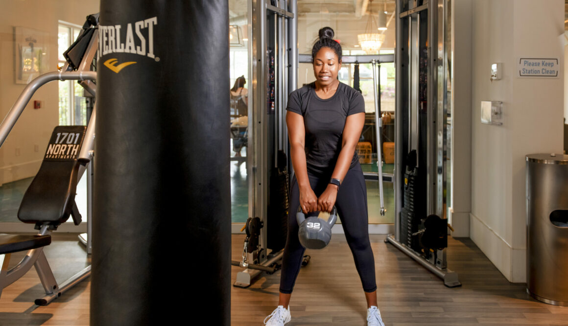 girl swinging kettle bell in evolve gym amenities blog