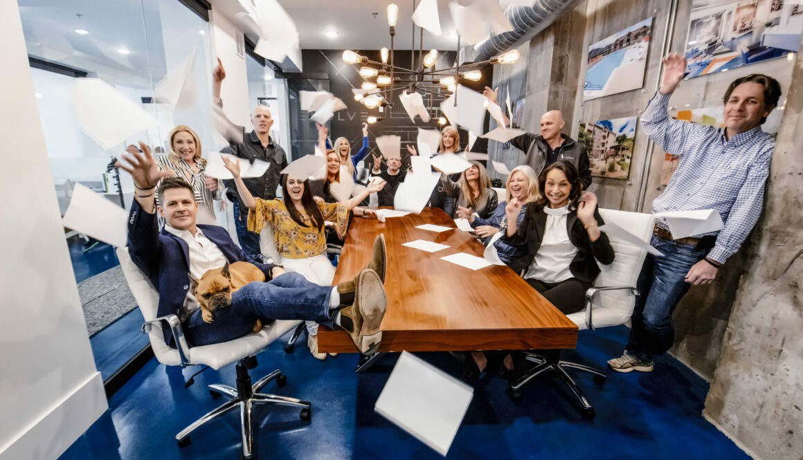 Evolve employees smiling and tossing papers in conference room