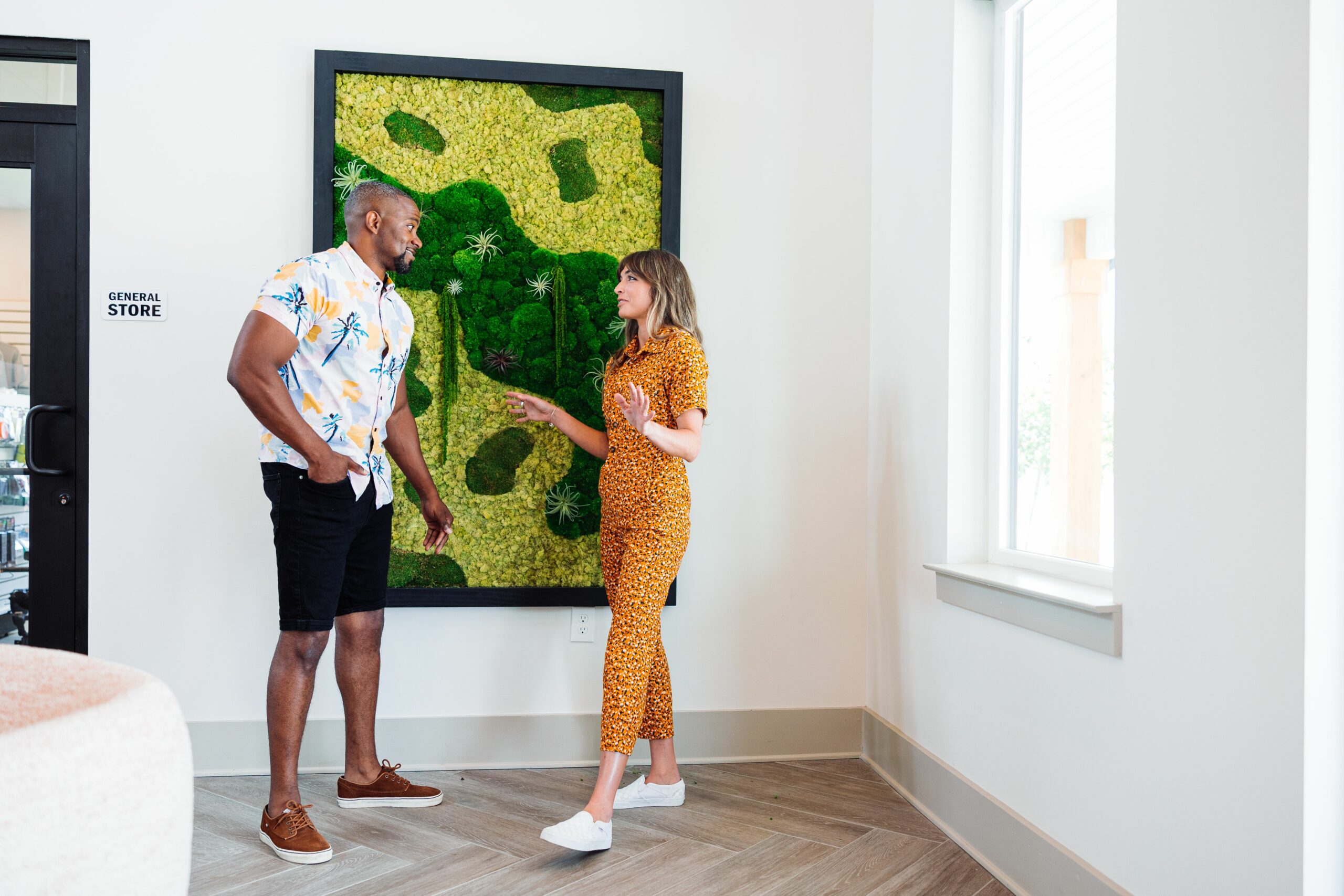 two people in front of plant art at oceans rv resort